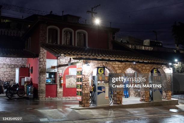 This photograph taken on August 30, 2022 in Lençois, Bahia state, Brazil, shows a petrol station with stone arches, at night.