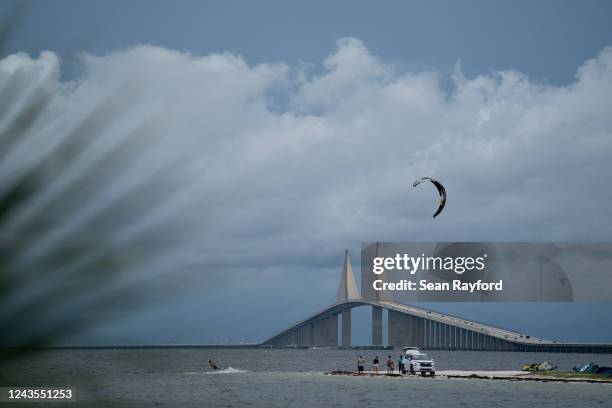 Person kite surfs near the Sunshine Skyway bridge as Hurricane Ian approaches on September 27, 2022 in St. Petersburg, Florida. Hurricane Ian is...