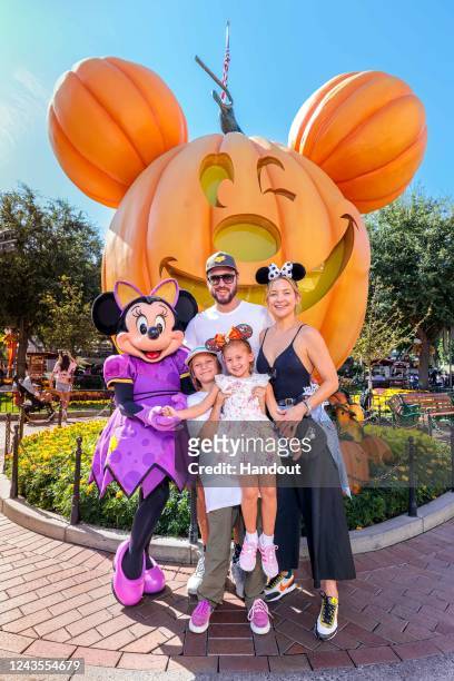In this handout image provided by Disneyland Resort, actress Kate Hudson and her family celebrate her daughter Rani Rose's birthday with Minnie Mouse...