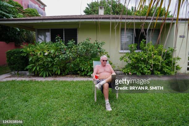 Steven Dame, refusing to evacuate, sits in a lawn chair having a drink while waiting for Hurricane Ian to make landfall on September 27, 2022 in St....