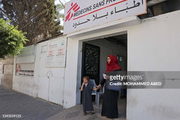 Four-year-old Yasser Khila is accompanied by his mother Dina after a dressing was applied to his wounds from spiled hot stew, at aclinic run by the...