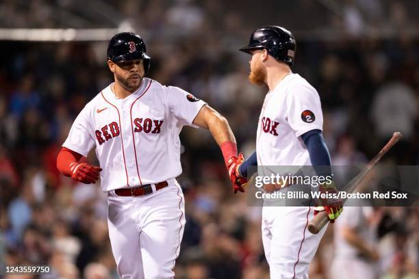 Tommy Pham of the Boston Red Sox high fives Alex Verdugo after scoring on a sacrifice fly during the third inning of a game against the Baltimore...