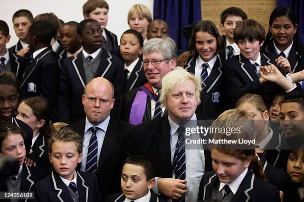 The Mayor of London Boris Johnson poses for photographs with author Toby Young and Headteacher Thomas Packer and pupils at the opening of the West...