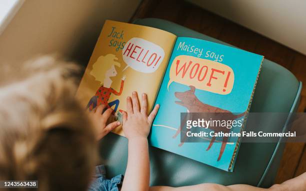 little girl reading a book - story book stock-fotos und bilder