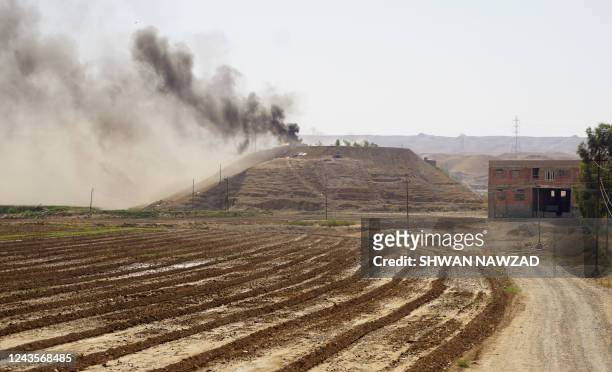 Smoke billows on the horizon in the village of Altrun Kupri, in the Sherawa region, south of Arbil in Iraq's Kurdistan, where a base of the Kurdistan...