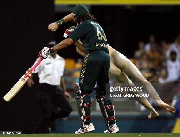 Australia's Andrew Symonds clashes with a streaker during the second final in the one-day triangular series cricket match in Brisbane on March 4,...