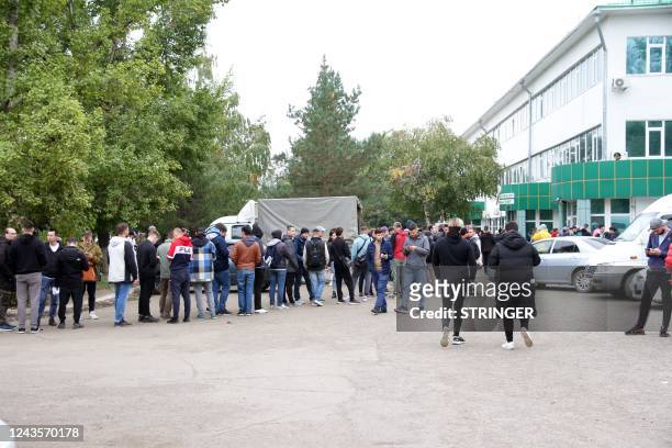 Russian citizens queue outside a public service centre to receive an individual identification number for foreigners in the city of Oral ,...