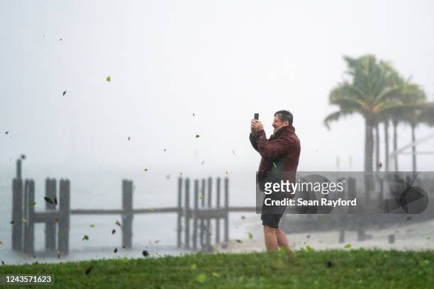 Peter Currin documents the weather at Sarasota Bay as a gust of wind carries leaves and debris while Hurricane Ian approaches on September 28, 2022...