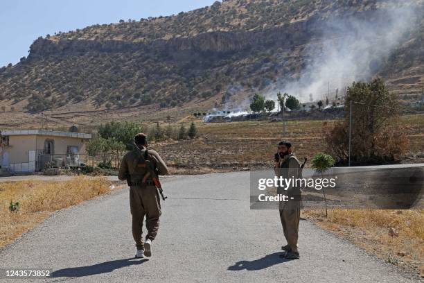 Kurdish peshmerga fighters walk to inspect the damage following an Iranian cross-border attack in the area of Zargwez, where several exiled left-wing...