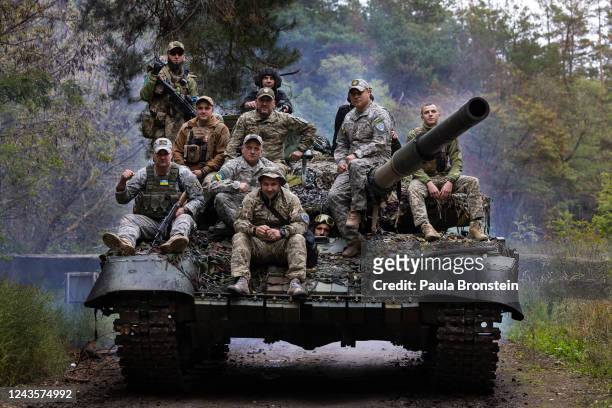 Ukrainian troops ride upon a repaired Russian tank in a wooded area outside the city on September 26 2022 in Kharkiv, Ukraine. Mechanics are...
