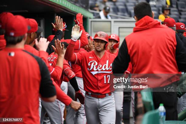 Kyle Farmer of the Cincinnati Reds celebrates with teammates in the dugout after hitting a two run home run in the ninth inning during the game...