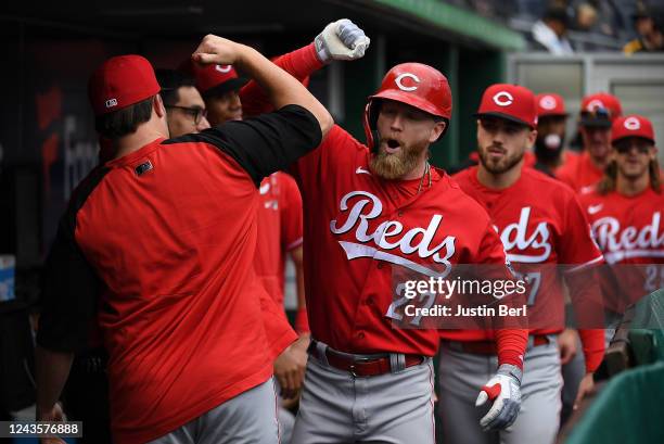 Jake Fraley of the Cincinnati Reds celebrates with teammates in the dugout after hitting a solo home run in the ninth inning during the game against...