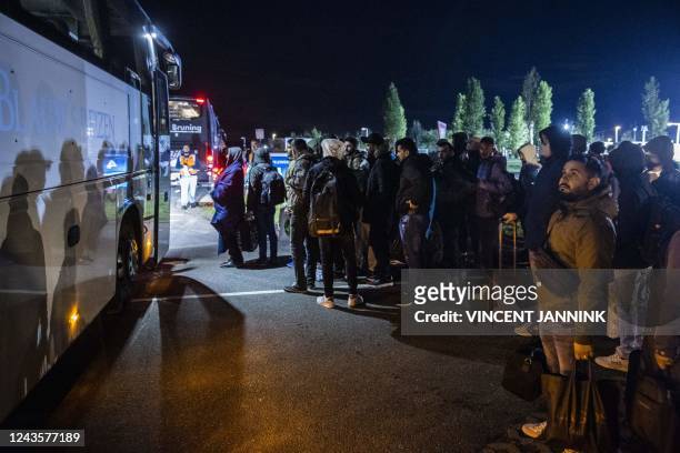 Asylum seekers board a bus to the emergency shelter at the application center in Stadskanaal, on September 28, 2022. - Once again, several dozen...