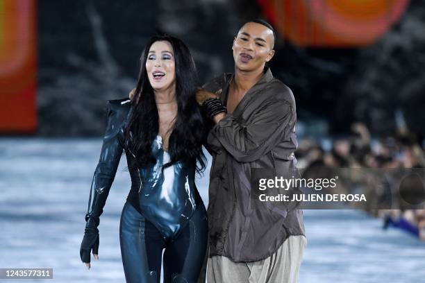 Singer Cher walks next to French fashion designer Olivier Rousteing as she presents a creation for the Balmain Spring-Summer 2023 fashion show during...