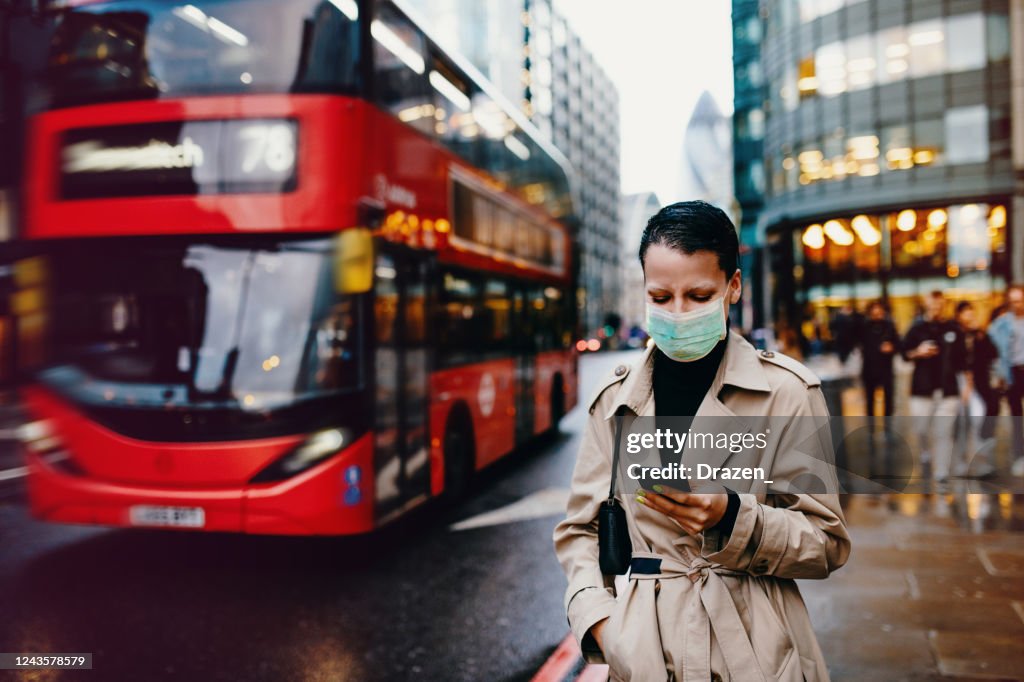 Trabajador esencial en Londres con máscara facial volver a casa después del trabajo con máscara facial en