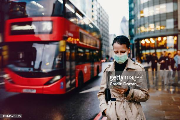 essentiële arbeider in londen met gezichtsmasker dat terug naar huis na het werk met gezichtsmasker op gaat - london england stockfoto's en -beelden