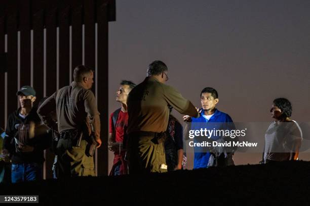 Border patrol agents take people into custody next to the U.S.-Mexico border fence where the last of the Colorado River flows into Mexico on...