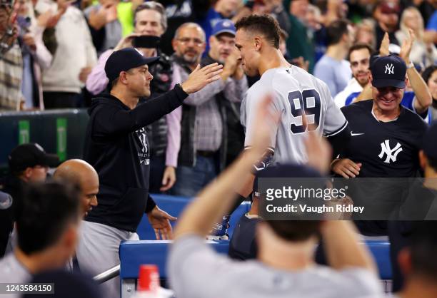 Aaron Judge of the New York Yankees is congratulated by manager Aaron Boone after hitting his 61st home run of the season in the seventh inning...