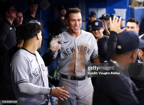 Aaron Judge of the New York Yankees is congratulated by teammates after hitting his 61st home run of the season in the seventh inning against the...