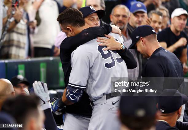 Aaron Judge of the New York Yankees is congratulated by manager Aaron Boone after hitting his 61st home run of the season in the seventh inning...