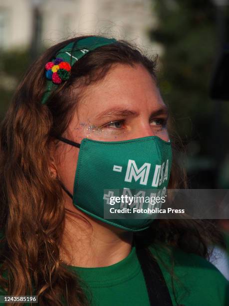 Mass, + Miso" can be read on a face mask when hundreds of women, wearing green scarf, carry out a demonstration demanding "Legal, safe and free...