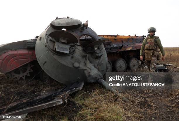 Ukrainian soldier walks past a destroyed Russian tank on the front line with Russian troops in Donetsk region on September 28, 2022.