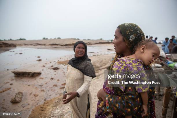 Reshum Bibi and Husna Bibi look towards their village that is submerged in water due to the recent floods and talk about how no one has come to help...