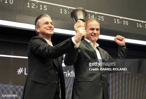 Oliver Blume , CEO of German car producer Porsche AG, and Lutz Meschke, member of the Porsche management board, ring the bell to launch the company's...
