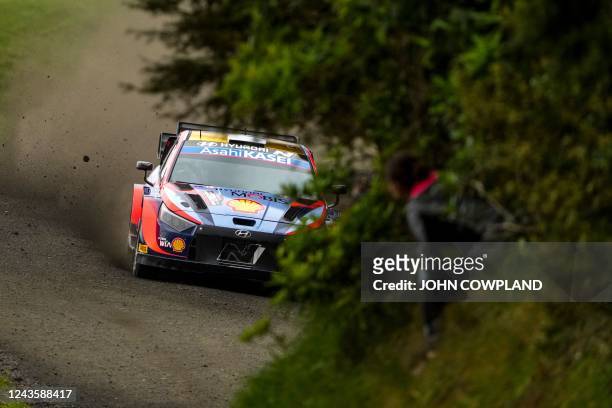Fan leans out for a better view of Estonia's Ott Tanak and co-driver Martin Jarveoja in their I20 N Rally 1 Hybrid during shakedown of the Rally New...
