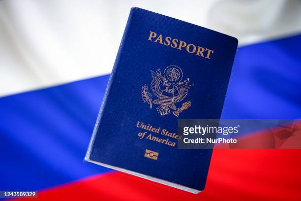 An American US passport is seen in this photo illustration with a Russian flag in the background in Warsaw, Poland on 29 September, 2022. Americans...