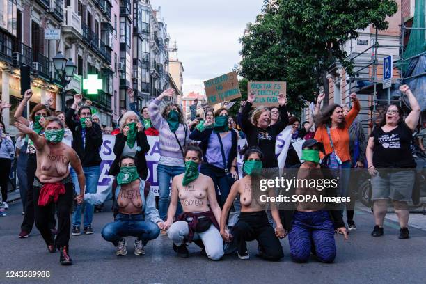Topless women kneel in the middle of the road while covering their faces with green handkerchiefs during the demonstration at the Justice Ministry...