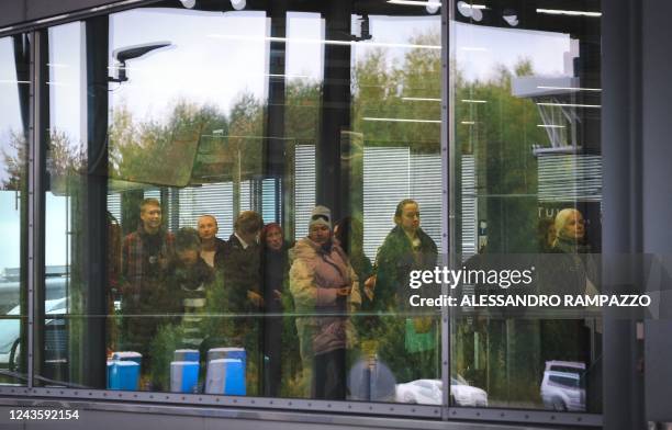 People queue at the passport check at the border checkpoint crossing in Vaalimaa, Finland, on the border with the Russian Federation on September 29,...