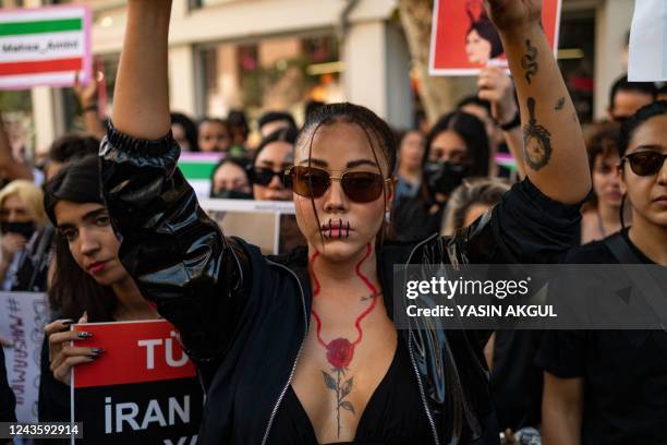 Protestors hold banners as they take part in a rally outside the Iranian consulate in Istanbul on September 29 as they protest following the death of...