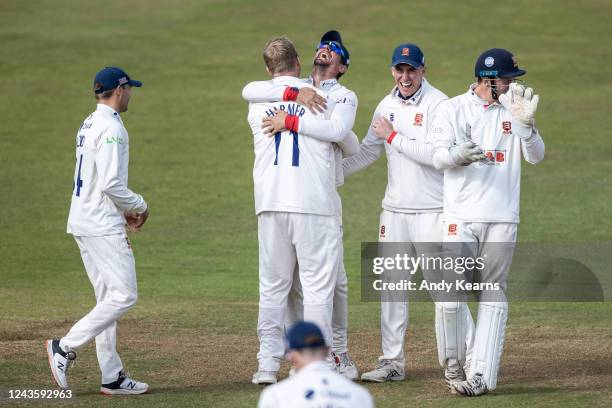 Simon Harmer of Essex is congratulated by his team mate Sir Alastair Cook after taking the wicket of James Sales of Northamptonshire during the LV=...