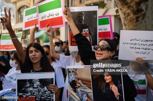 Protestors shout slogans as they hold banners with the portrait of Iranian Mahsa Amini while they take part in a rally outside the Iranian consulate...