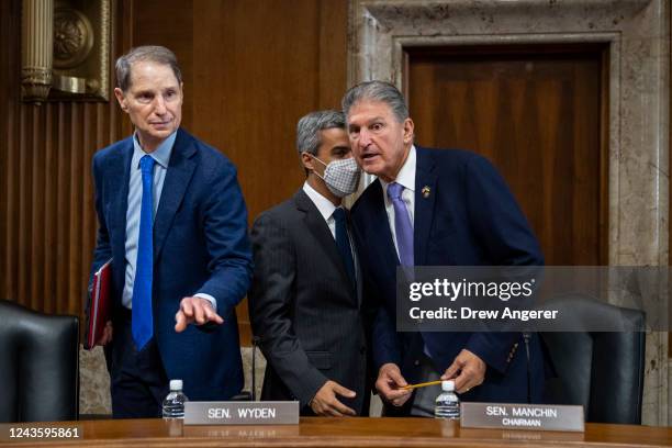 Sen. Ron Wyden looks on as Sen. Joe Manchin confers with an aide as he arrives for a Senate Committee on Energy and Natural Resources hearing on...