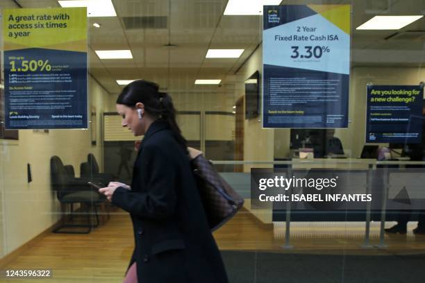Pedestrian passes notices advertising savings rates in the window of an Building Society in London on September 29, 2022. - The plan for...
