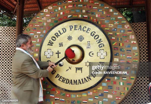 Brazilian President Luiz Inacio Lula da Silva strikes the World Peace Gong during a visit to the Mahatma Gandhi memorial, "Tees January Marg, the...