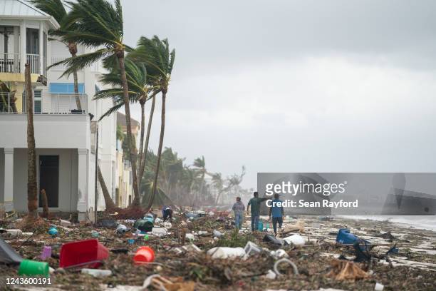 People walk along the beach looking at property damaged by Hurricane Ian on September 29, 2022 in Bonita Springs, Florida. The storm made a U.S....