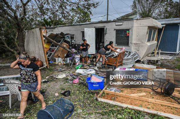 Residents of mobile homes clean up debris in the aftermath of Hurricane Ian, in Fort Myers, Florida, on September 29, 2022. - Hurricane Ian left much...