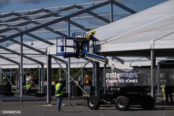 Workers install tents to handle an influx of asylum-seekers, in a parking area of Orchard Beach, in the Bronx, New York on September 29, 2022.
