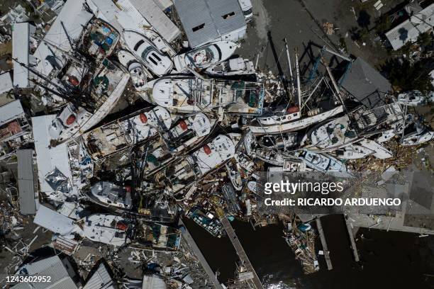 An aerial picture taken on September 29, 2022 shows piled up boats in the aftermath of Hurricane Ian in Fort Myers, Florida. - Hurricane Ian left...
