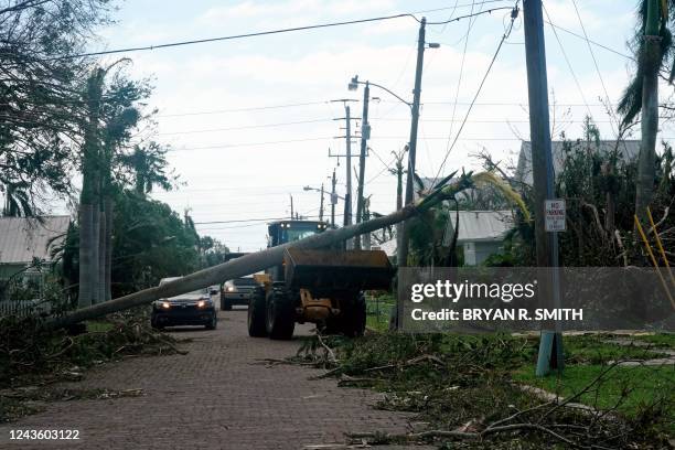 Road crew attempts to remove a fallen palm tree from a power line in the aftermath of Hurricane Ian in Punta Gorda, Florida on September 29, 2022. -...