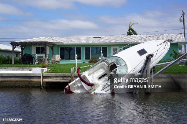 Boat lays sideways in the canal in the aftermath of Hurricane Ian in Punta Gorda, Florida on September 29, 2022. - Hurricane Ian left much of coastal...