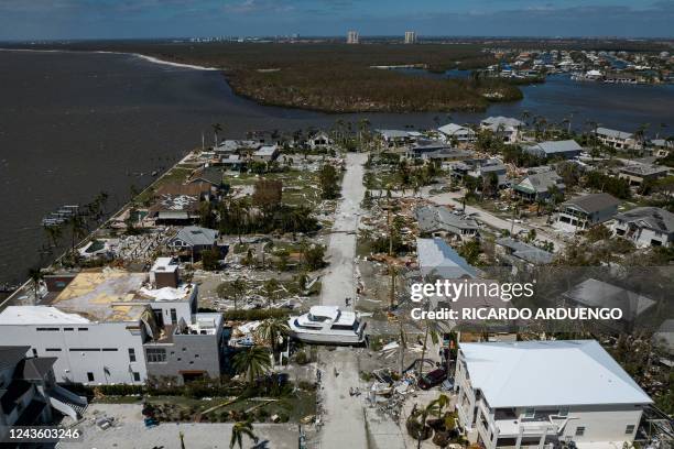 An aerial picture taken on September 29, 2022 shows a big washed up boat sitting in the middle of a street in the aftermath of Hurricane Ian in Fort...