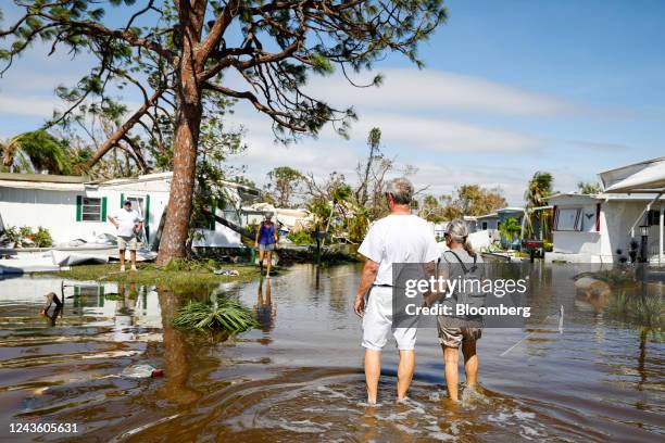 People walk on a flooded street at a trailer park following Hurricane Ian in Fort Myers, Florida, US, on Thursday, Sept. 29, 2022. Ian, now a...