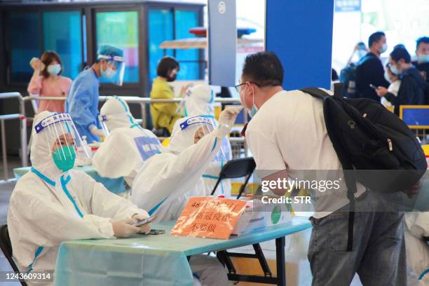 This photo taken on September 29, 2022 shows a passenger undergoing a nucleic acid test for the Covid-19 coronavirus at Suzhou Railway Station in...