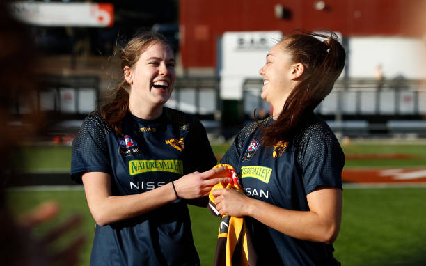 Jenna Richardson of the Hawks receives her jumper from Emily Everist of the Hawks on debut during the 2022 S7 AFLW Round 06 match between the...