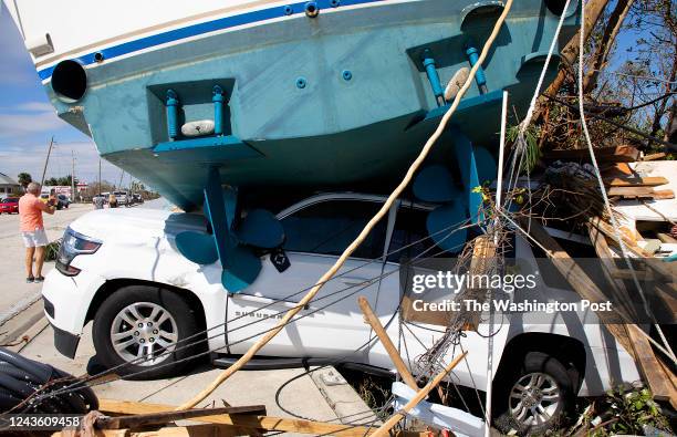 Hurricane Ian storm surge washed a large boat on top of a vehicle damage at Fort Myers Beach on Thursday, September 29, 2022.