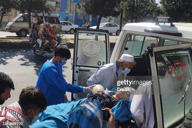 Relatives and medical staff shift a wounded girl from an ambulance outside a hospital in Kabul on September 30 following a blast at a learning centre...